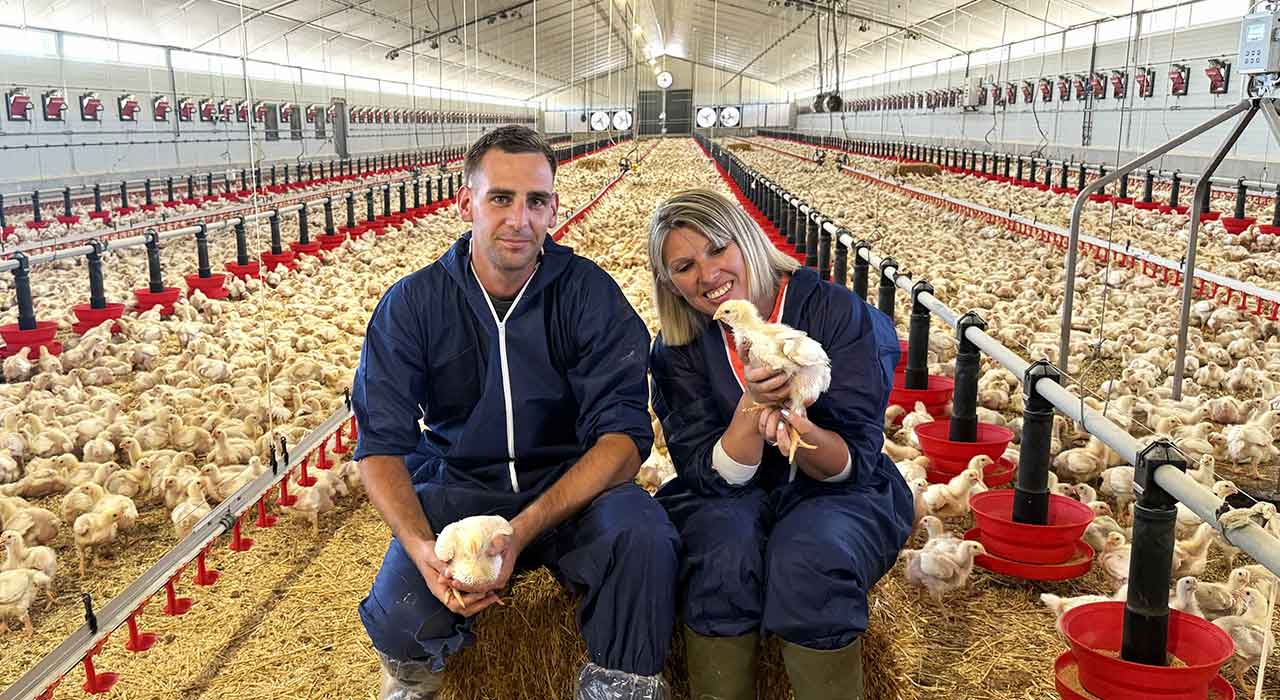 Sylvie Roche et son technicien consultant sur l'exploitation assis sur une botte de paille pour faire une photo