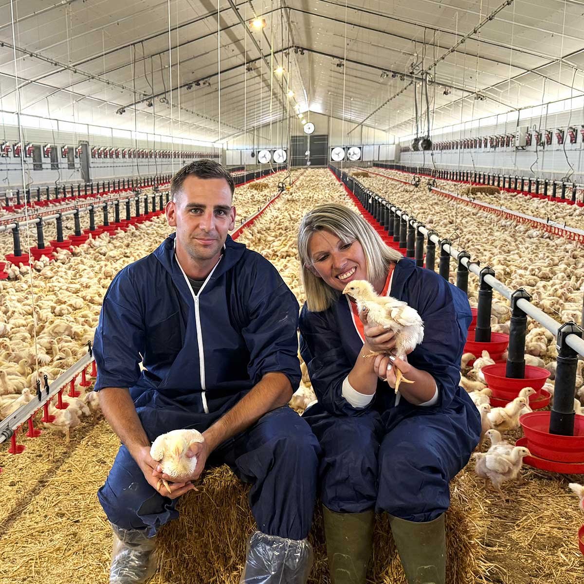 Sylvie Roche et son technicien consultant sur l'exploitation assis sur une botte de paille pour faire une photo
