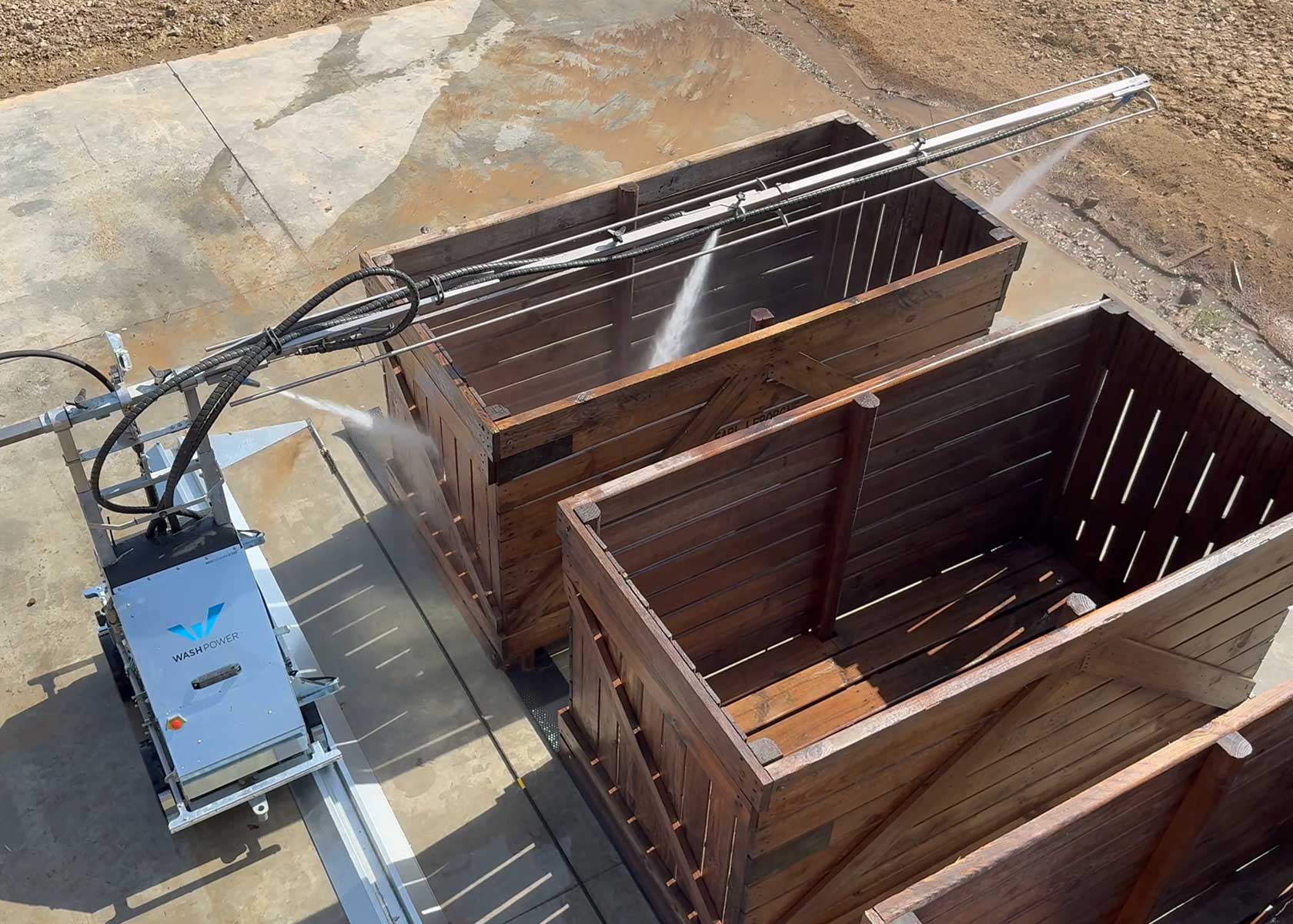 Le robot de lavage C100 en train de laver des palox à plants de pommes de terre.